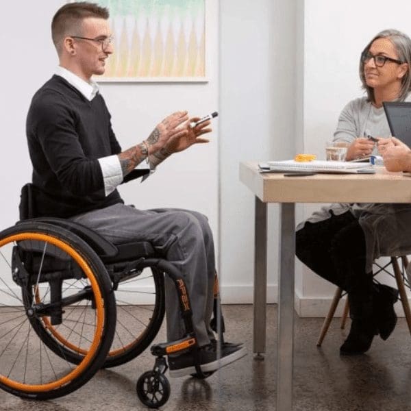 man in wheelchair talking to a woman