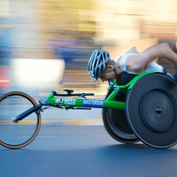 man propelling a wheelchair at speed