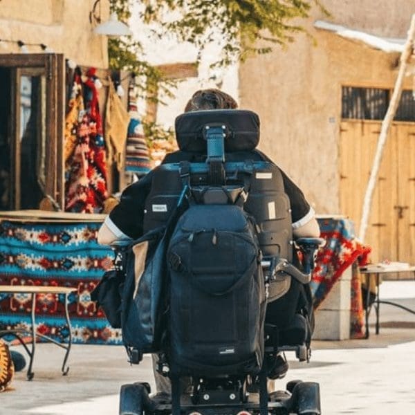 person in a powerchair shopping in a street market