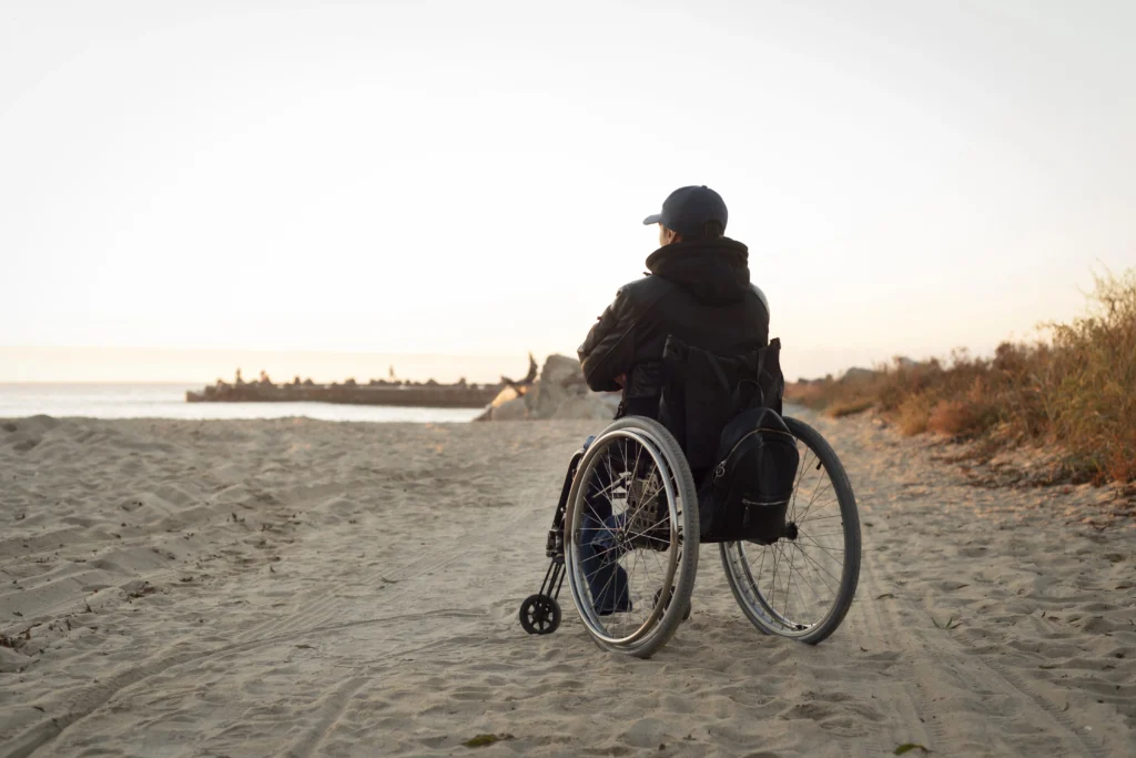 Friedrichs ataxia man in wheelchair on beach in dubai