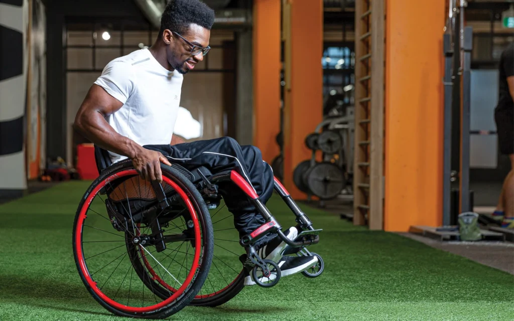 Motion composites carbon red wheelchair man on two wheels
