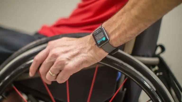 Man in a wheelchair is using an Apple Watch